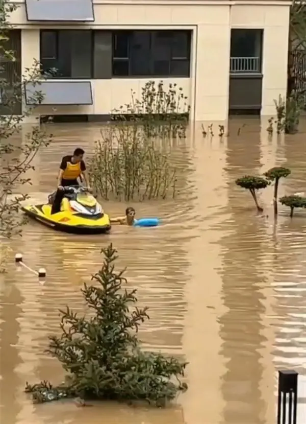 洪水救人视频_洪水救援人员_男子10次潜入洪水为救援队开小区大门